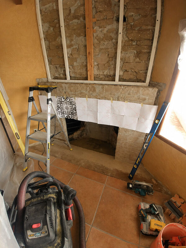 Paper templates for the tile layout, taped to the masonry
