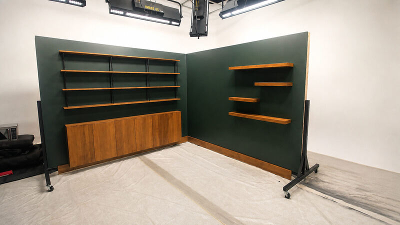 Forest-green flats, cherry floating shelves, black strap standards