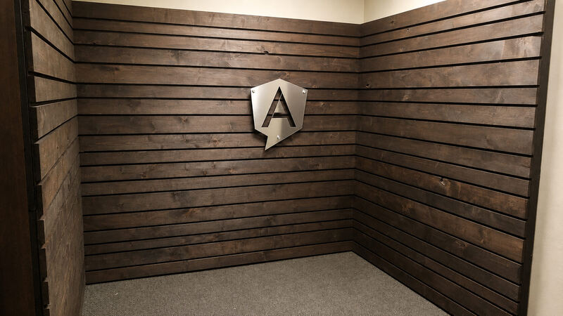 A booth in walnut shiplap with black reveals