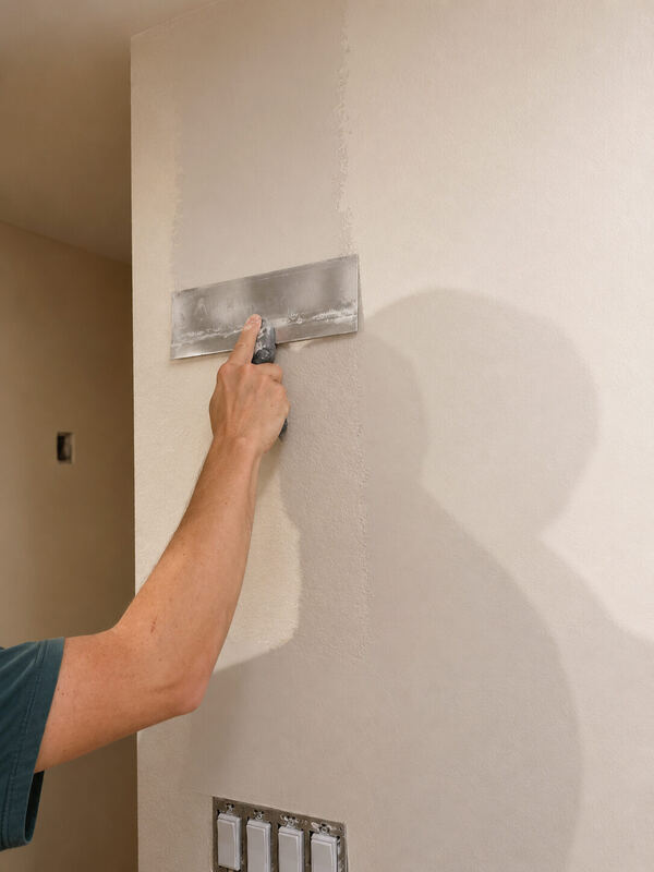 The wet edge: old texture on one side, flat plaster on the other