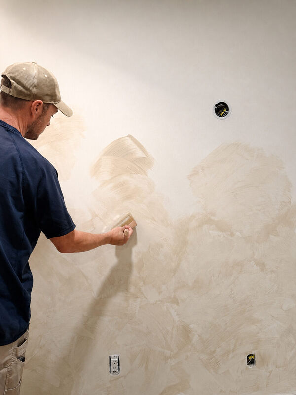 Lime wash goes on in crossed strokes — the movement is built, not sprayed
